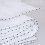 Housse de couette AYA de luxe en coton blanc épuré avec détails de lignes de boutons en passementerie faits main.
