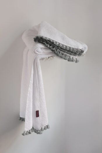 Drap de douche LAMU original blanc en éponge de coton lourd avec finitions de pompons de couleur façonnés à la main.